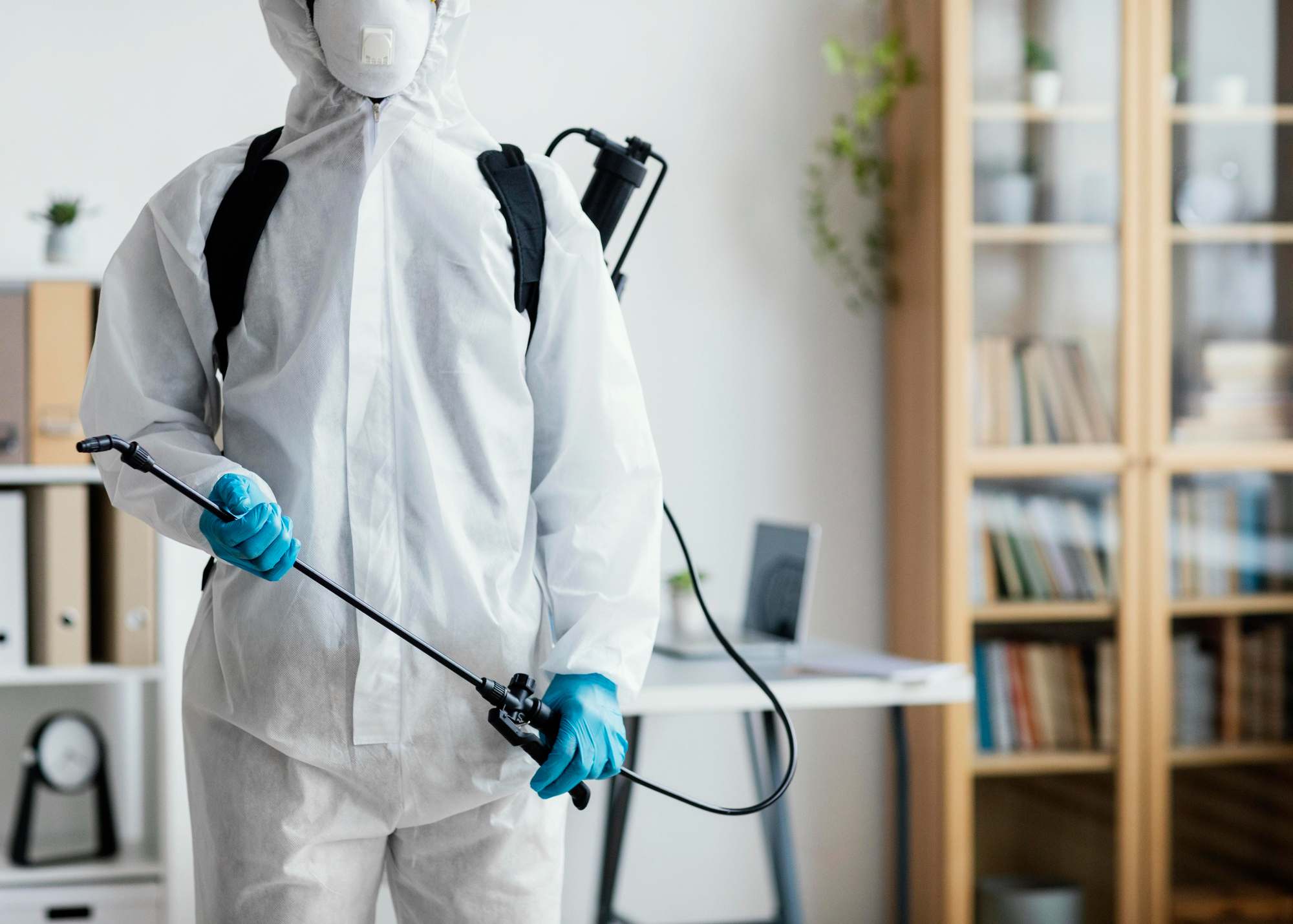 person-in-protective-equipment-disinfecting